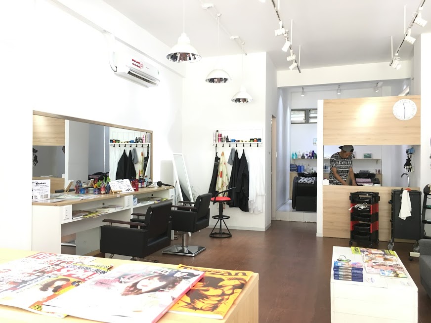 Khu vực gội đầu với bồn rửa lát gạch và gương ngang phục vụ khách.